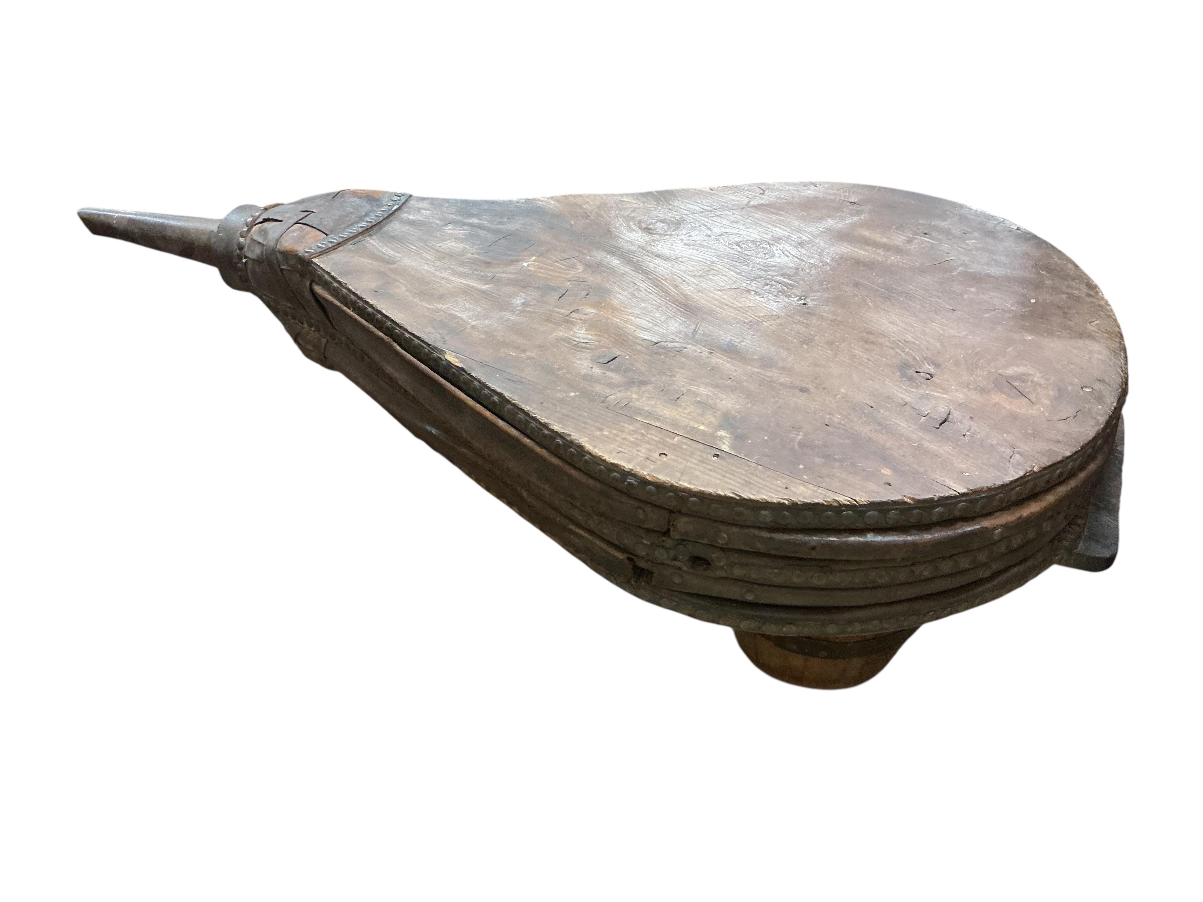 A set of 19th century iron and leather mounted oak blacksmith's bellows, now as a coffee table on twin barrel supports, width 63cm, depth 80cm, height 59cm